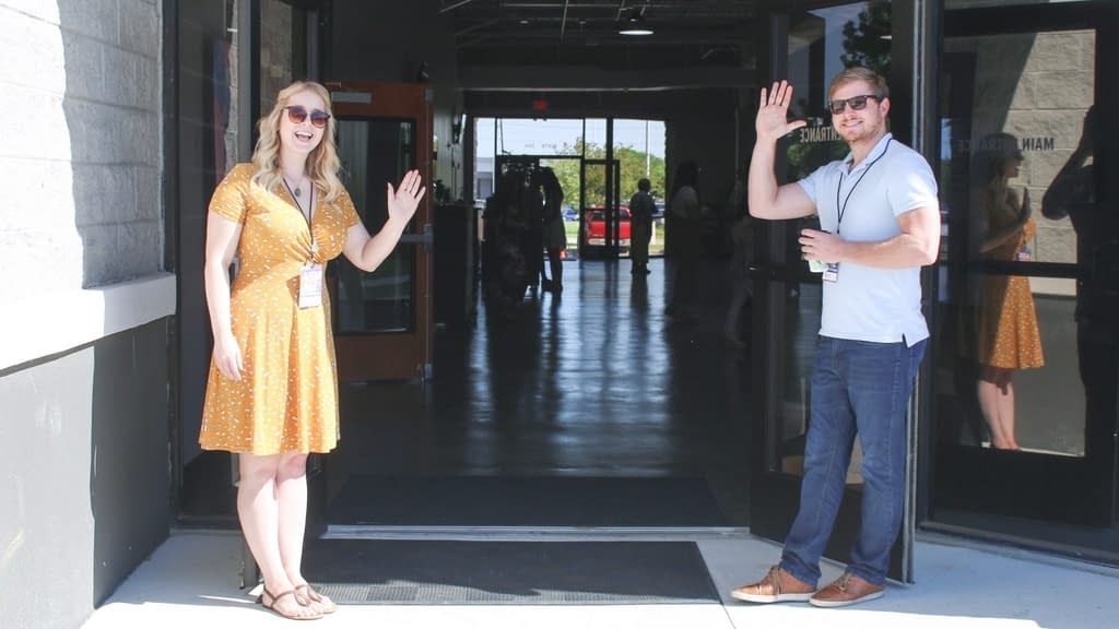 Man and Woman waving and greeting people at accommodation