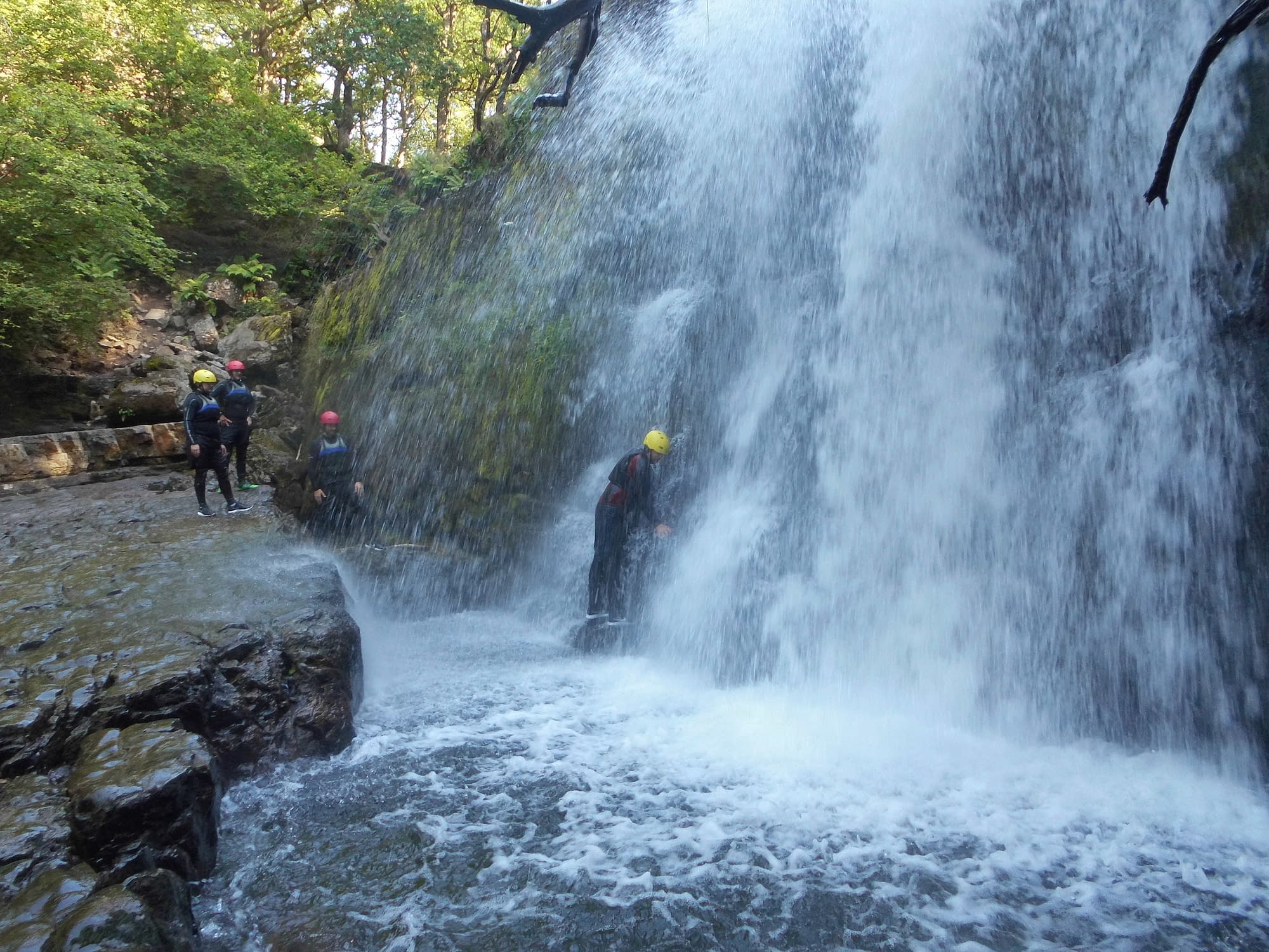 Walking through one of South Wales' waterfalls whilst canyoning near Cardiff
