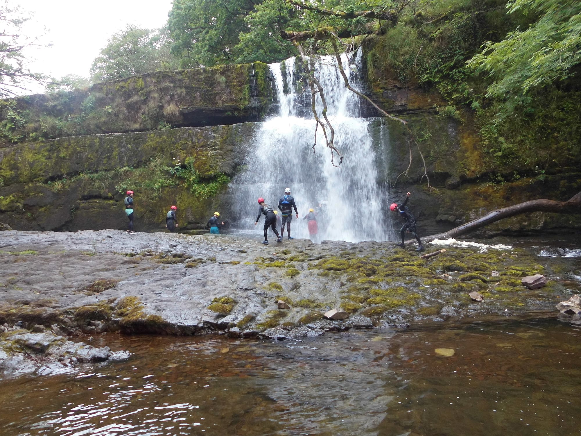 Walking past a large waterfall whilst gorge scrambling