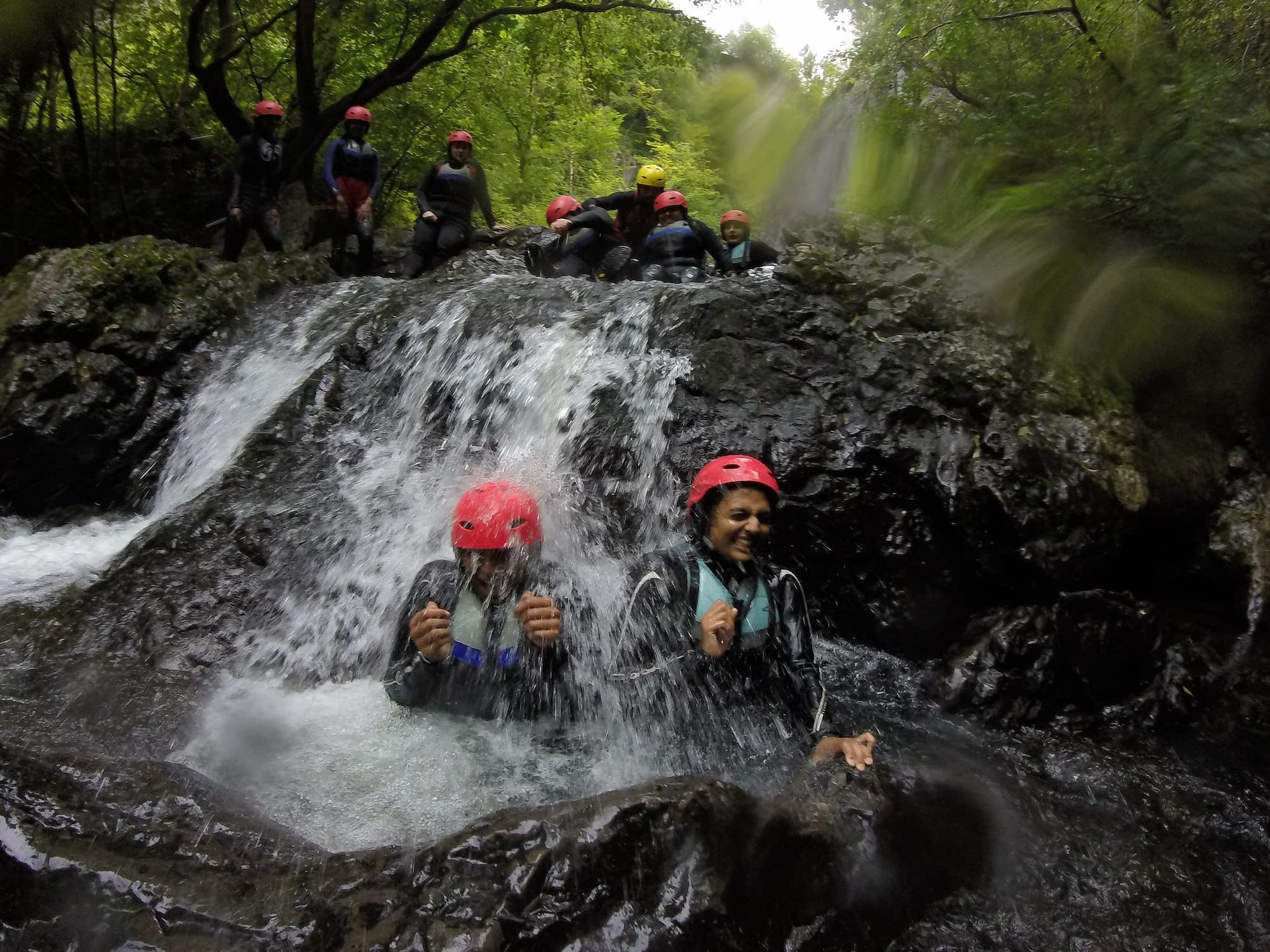 Two women getting splashed by white water during gorge walking