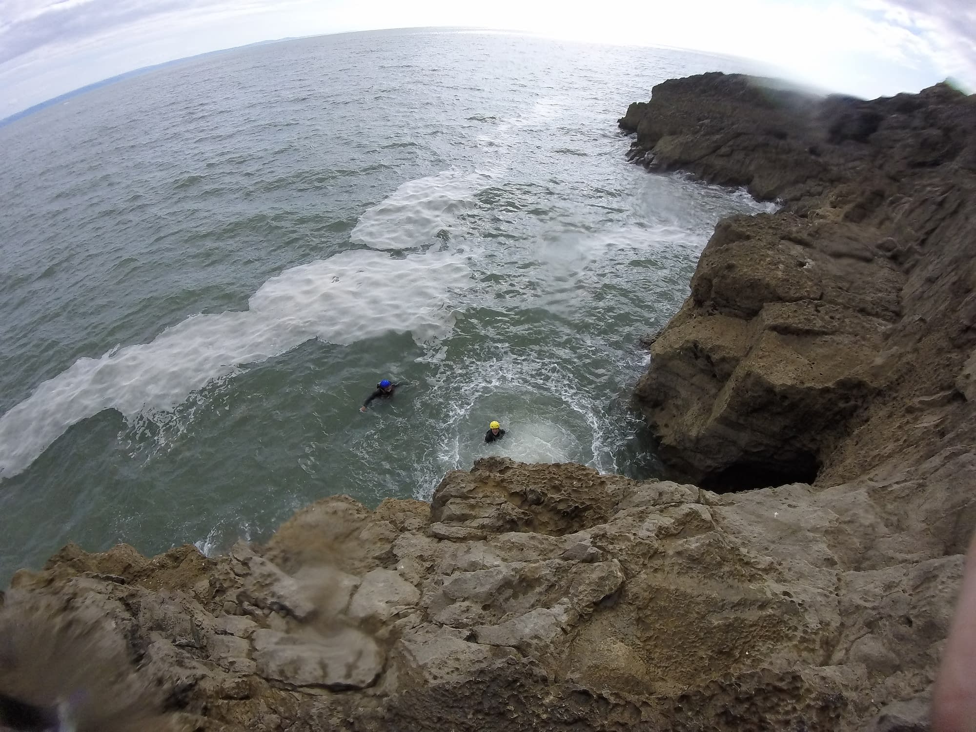 People swimming in sea after big coasteering jump