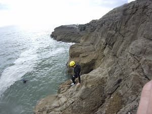 Traversing a cliff in South Wales during Coasteering activity