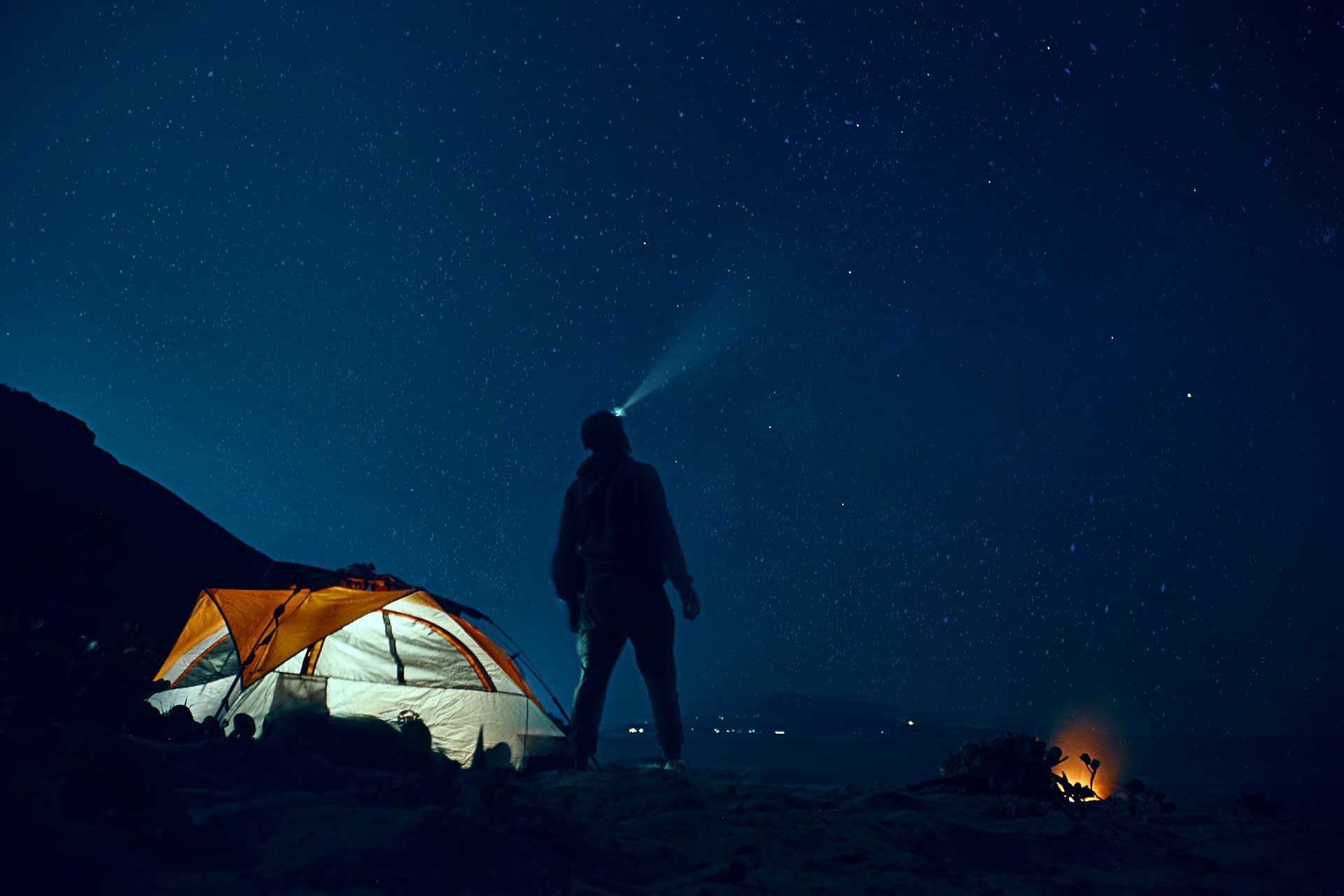 Man stood outside tent at night