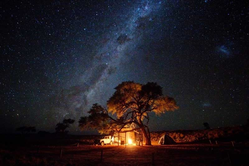 Night sky full of stars in Kruger Safari Park with a fire burning in a camp