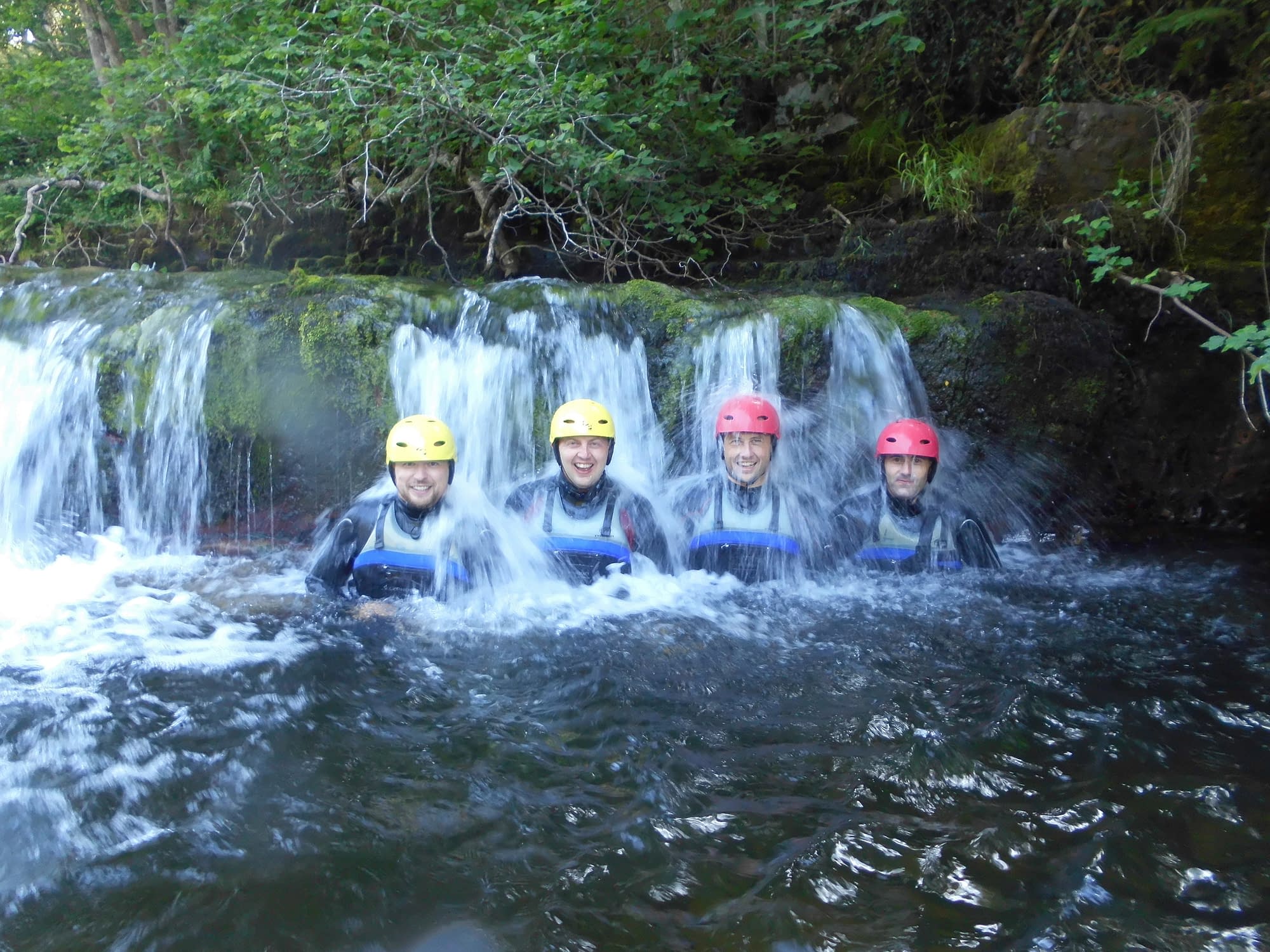 Group of 4 in a waterfall plunge pool whilst canyoning near Cardiff